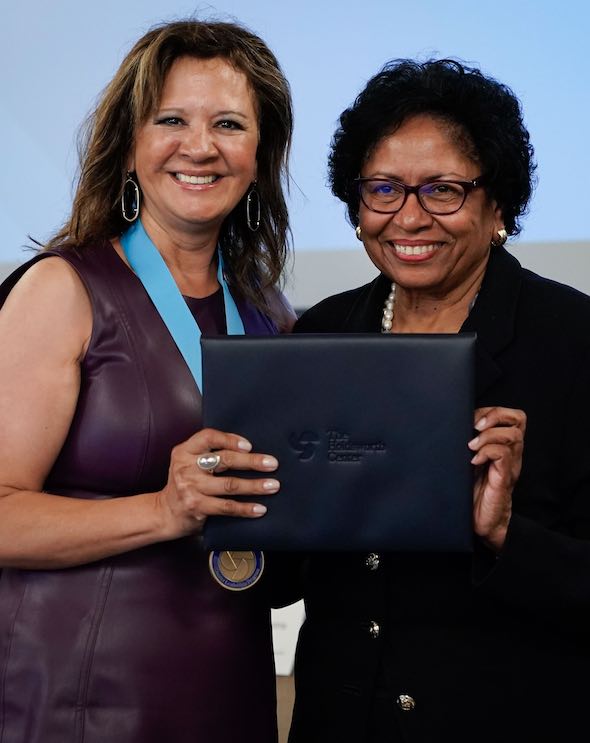 Dr. Nora Rivas-Garza of PSJA is pictured on stage receiving an award from Dr. Ruth Simmons, board chair of The Holdsworth Center.